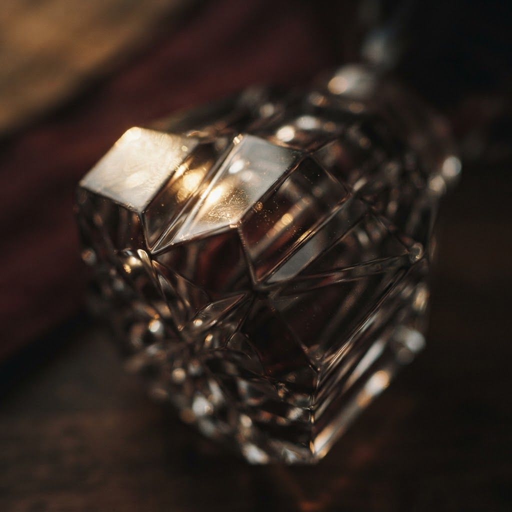 Close detail of a cut-crystal decanter catching warm light